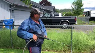 Moss man hydrotilling  cutting tall grass through a fence tilling with a pressure washer garden