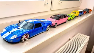 Bigger and Small Diecast model cars driven by hand on the windowsill