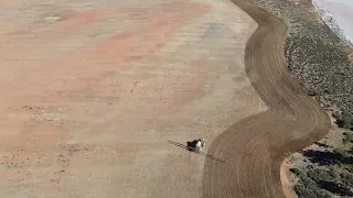 seeding and spraying next to the wind farm and lake