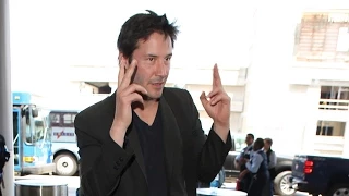 Keanu Reeves Flashes A Double Peace Sign At LAX As Onlookers Gush