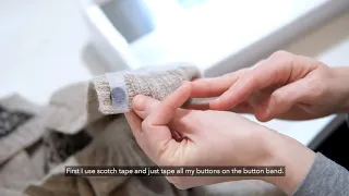 Machine sewing buttons on a hand knit sweater
