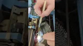 Maintenance workshop: Cleaning inside an Olivetti typewriter.