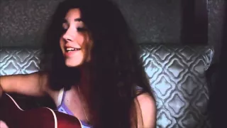 Кудрявая девушка красиво поет и играет на гитаре