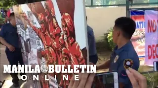 NCRPO personnel confiscate a mural depicting the call to convict the accused of Maguindano Massacre