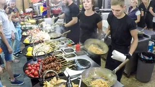 Many Woks Cooking Fish and Noodles. Kiev Street Food, Ukraine