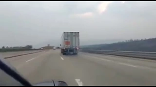 Runaway trailer truck being escorted by the police to an emergency runaway lane