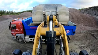 a day at work Caterpillar 972M XE wheel loaders loads truck and dumpers