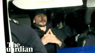 Andrew Tate escorted by Romanian police officers after raid