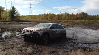 White Cherokee trailhawk playing in the mud
