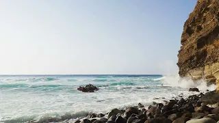 Sea cliff and white foam of waves