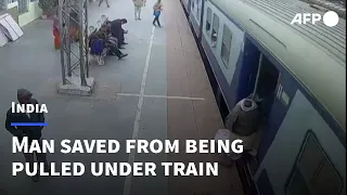 Indian soldier saves man from being pulled under a moving train | AFP