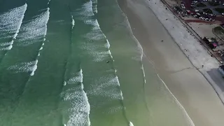 Surfing the Waves and beautiful scenery of Muizenberg Beach by The Lens