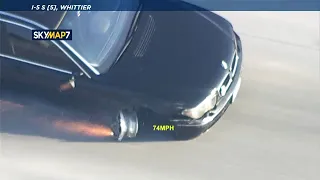 CHASE: BMW tire blows out down to rim, throws sparks on freeway