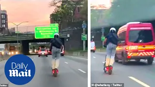 Crazy moment New York man rides electric scooter down highway