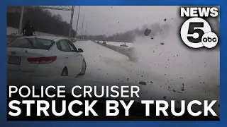 Video shows truck crash into police cruiser; officer narrowly avoids being struck