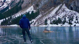 lonely ice skating on a black frozen mountain lake / slow tv nature