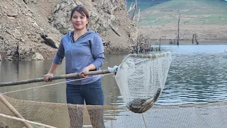 The girl uses a giant trap to catch fish at night. Use a fish bait bulb. Life on the lake.