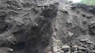 Excavators work to dig up sand to pile up previous mining waste rock