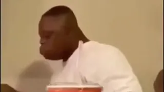 Black man falls off chair