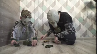 Children in gas mask from viruses play with toys
