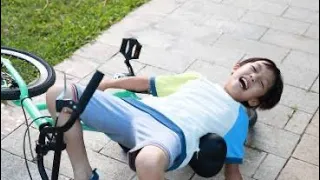 Asian kid falls off bike