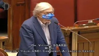 Sgarbi con la mascherina solo sul naso, portato via di peso (di nuovo) dai commessi: «Ritornerò»