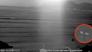 Surfer paddles out in the dark at Muizenberg beach surfers corner. Filmed from live stream webcam