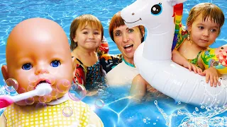 Kids pretend to play with baby dolls. Baby Annabell morning routine. Feeding time. Swimming pool fun