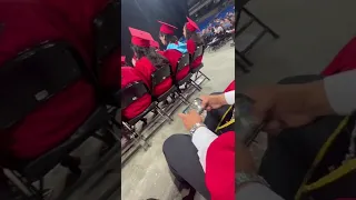 Somebody playing clash of clans during his graduation