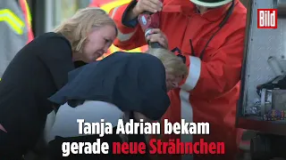 Frau bekommt von der Feuerwehr die Haare gewaschen.