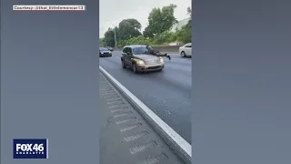 Shocking video shows man hanging on hood of car down I-77