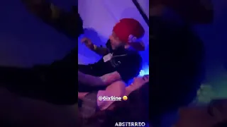 6ix9ine sits next to a woman