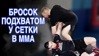 Бросок подхватом у сетки в ММА.