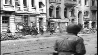 US Army soldiers advancing along ruined streets of Cologne, under fire, and break...HD Stock Footage