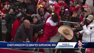 Mahomes, wearing WWE title belt, chugs a beer during the parade