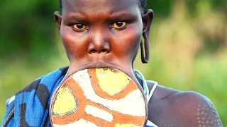 Surma tribe woman removing an putting her lip plate, Omo Valley Ethiopia