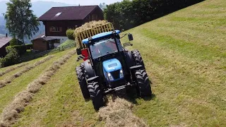 Heuernte in den Hängen der Voralpen mit einem REFORM METRAC und einem NEWHOLLAND TN75D