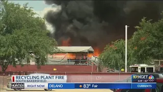 Firefighters work to put out flames at recycling facility