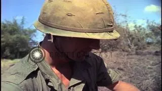Soldiers listen to a captured Vietcong record player and wade across narrow strea...HD Stock Footage