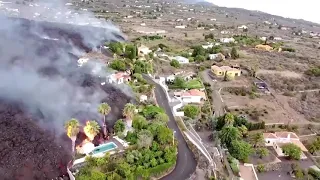 Drone footage showed lava from Spanish La Palma volcano swallowing a swimming pool & houses.