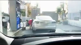 Blonde woman in a Gas Station with a Tesla Model S