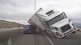 Astonishing moment a 70mph gust of wind blows an 18-wheeler on top of a cop car after driver.