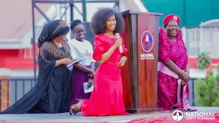 FIRST LADY KNEELS DOWN AS SHE INVITES H.E PRESIDENT BOBI WINE THE HUSBAND TO CELEBRATE THE WOMEN