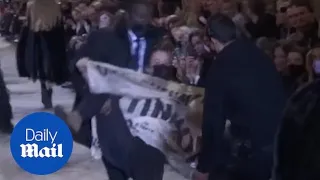 Extinction Rebellion protestor tackled by security at fashion show