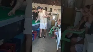 Windersson Nunes humilde de mais fumando  um cigarro e jogando uma sinuca em um bar simples