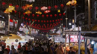 Moving down the busy night market at Jalan Alor street food market with Chinese lanterns overhead