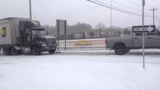 Dodge Ram pulls fully loaded semi on ice.