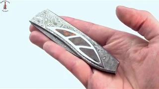 Emil Bucharsky folding knife with ammonite inlay and pool and eye pattern damascus blade