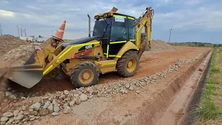 operando una retroexcavadora y recogiendo material y acopiandolo, tambien enseño un truco