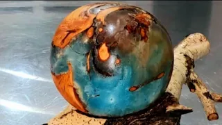 "Our Precarious World"  Resin, Willow wood sphere on Birch lathe turned. O.U.R. at ArtForOUR.org